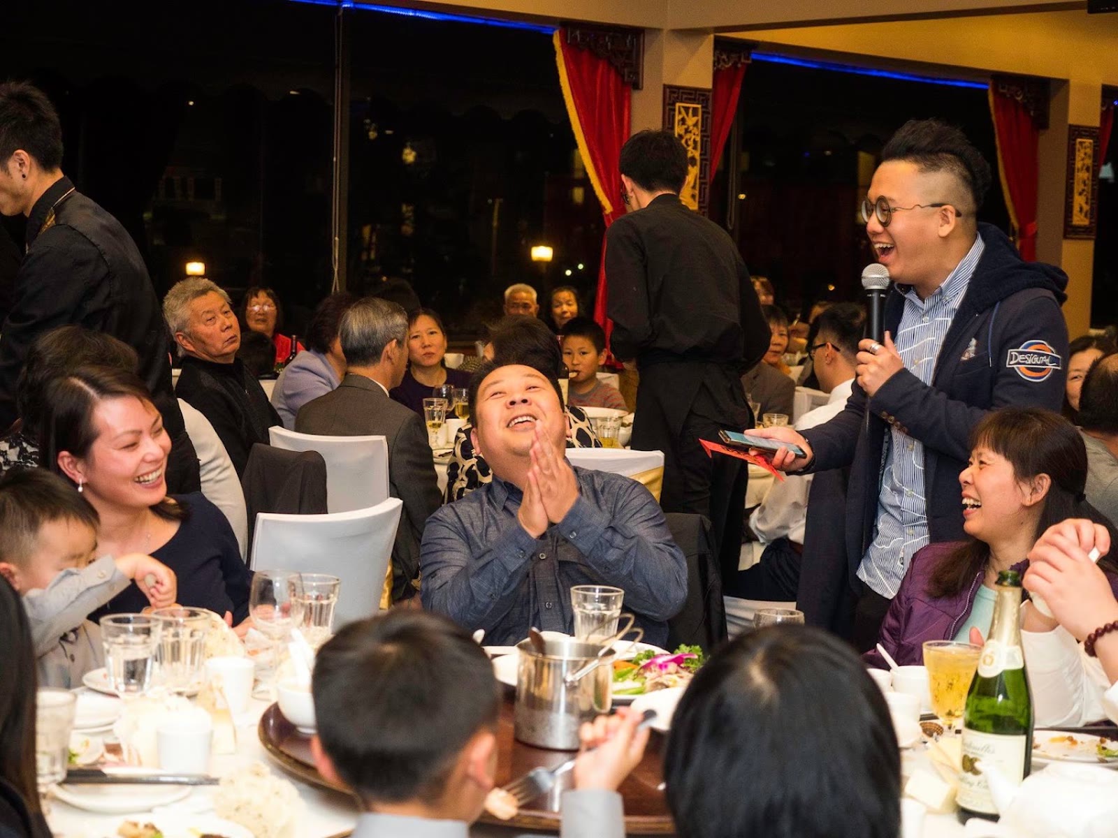 Foksifu on the microphone getting a Chinese wedding banquet crowd laughing and engaged