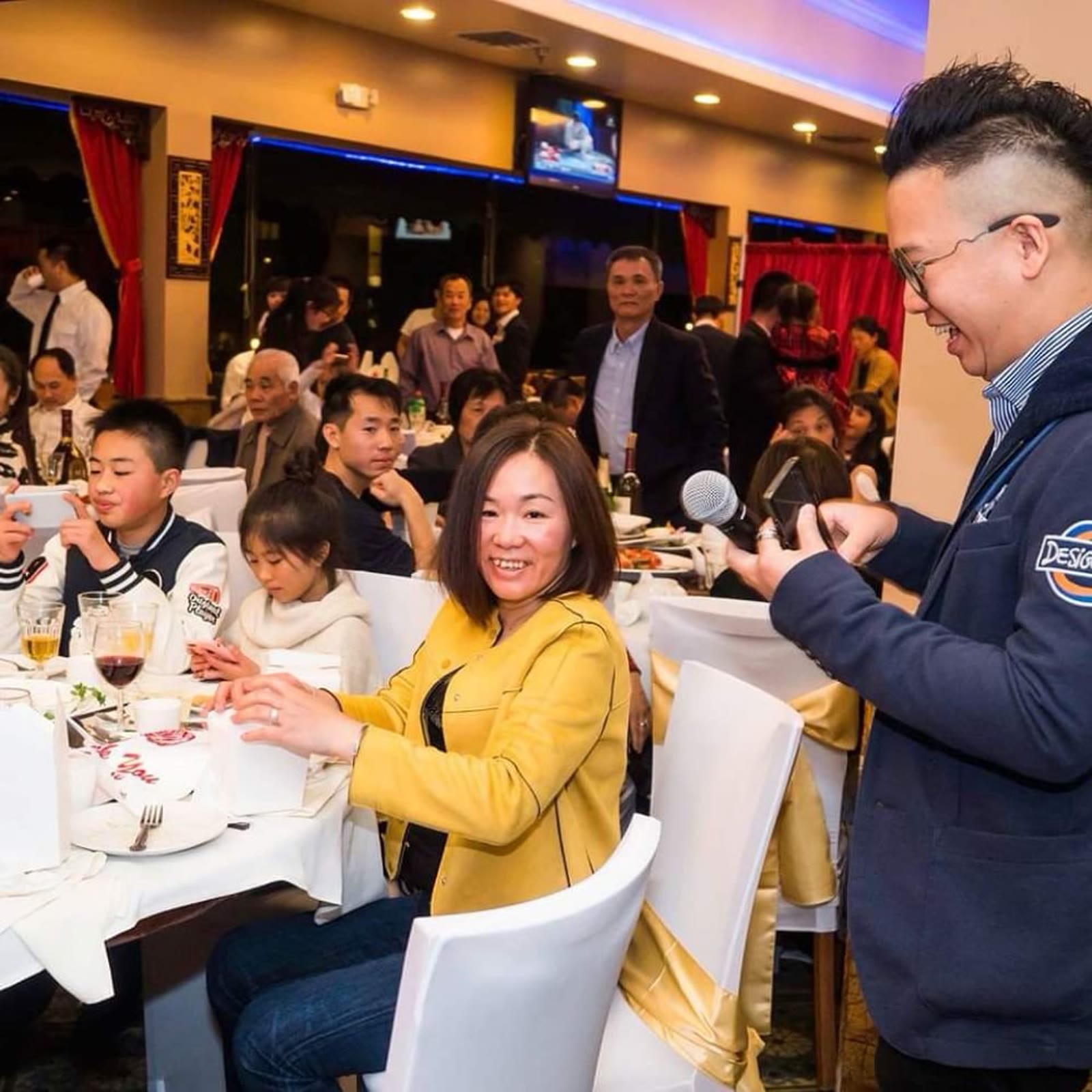 Foksifu on the microphone engaging directly with guests at a Chinese wedding banquet in the Bay Area